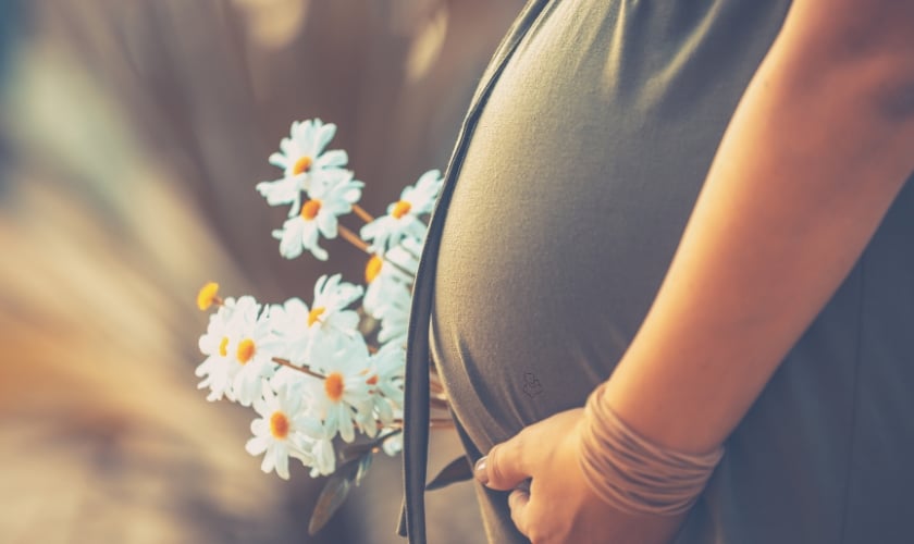 A pregnant woemn showing her baby bumb.