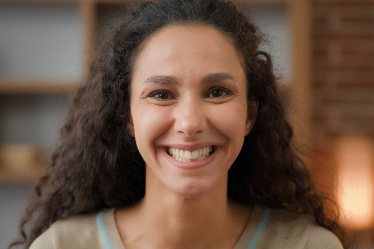 Woman smiling confidently, reflecting success and positivity.