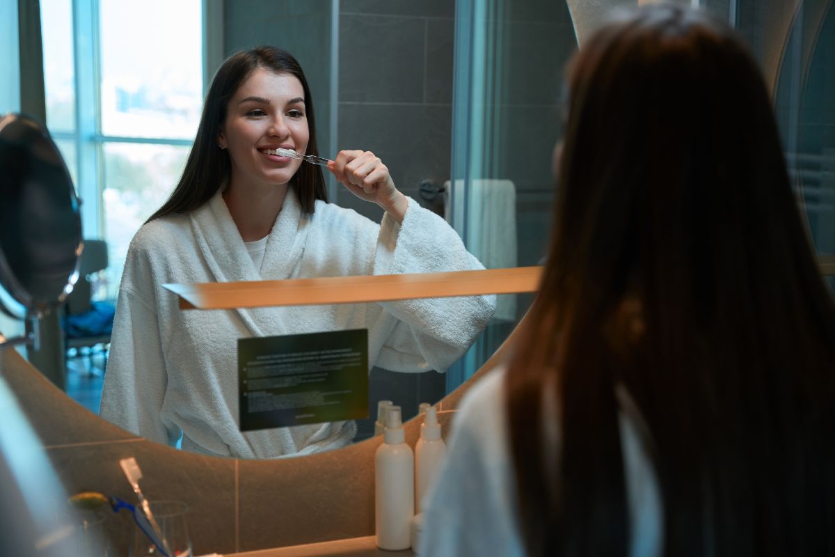 Person brushing teeth with a toothbrush and toothpaste for good oral hygiene.