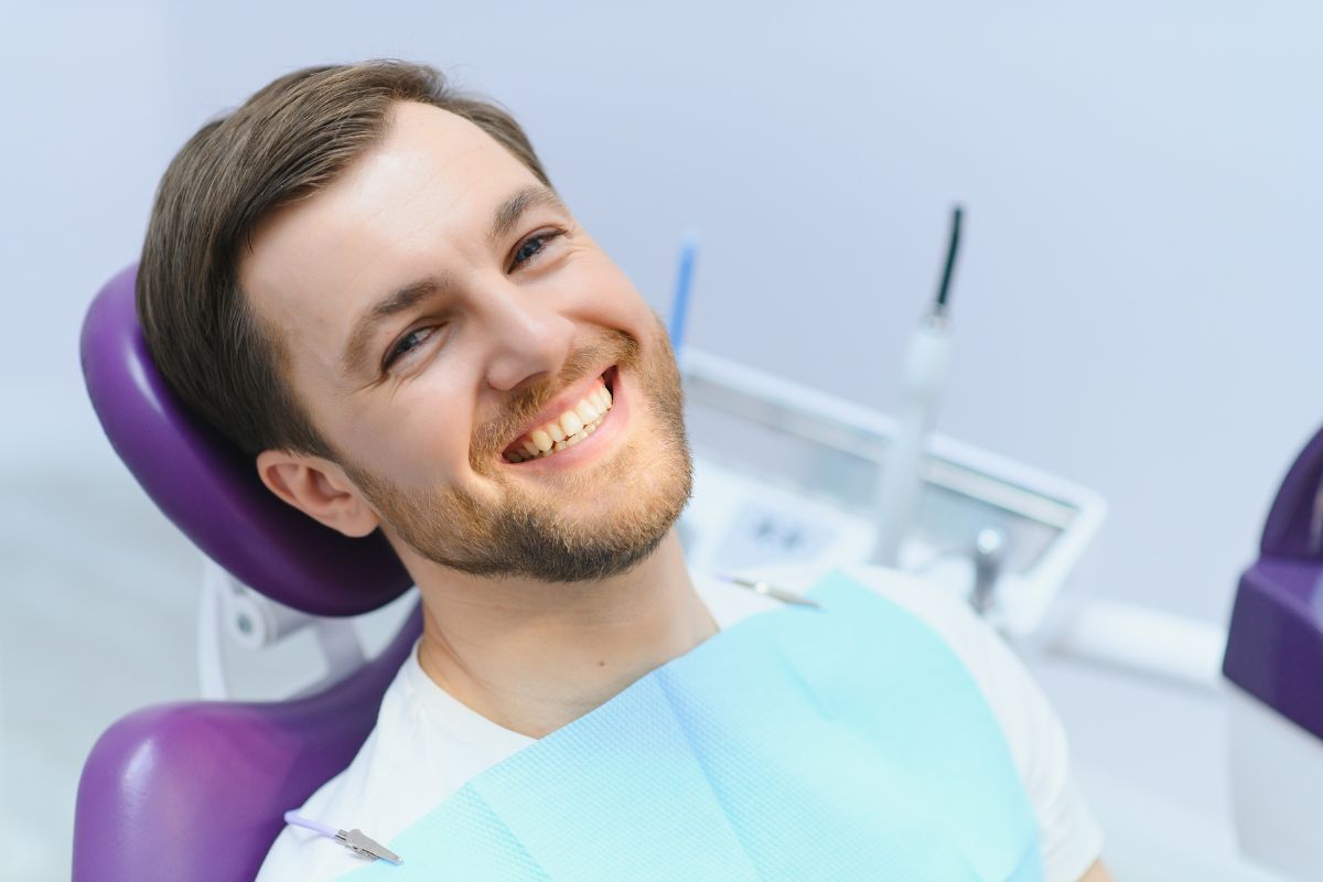 Patient smiling after teeth whitening treatment with minimal tooth sensitivity.