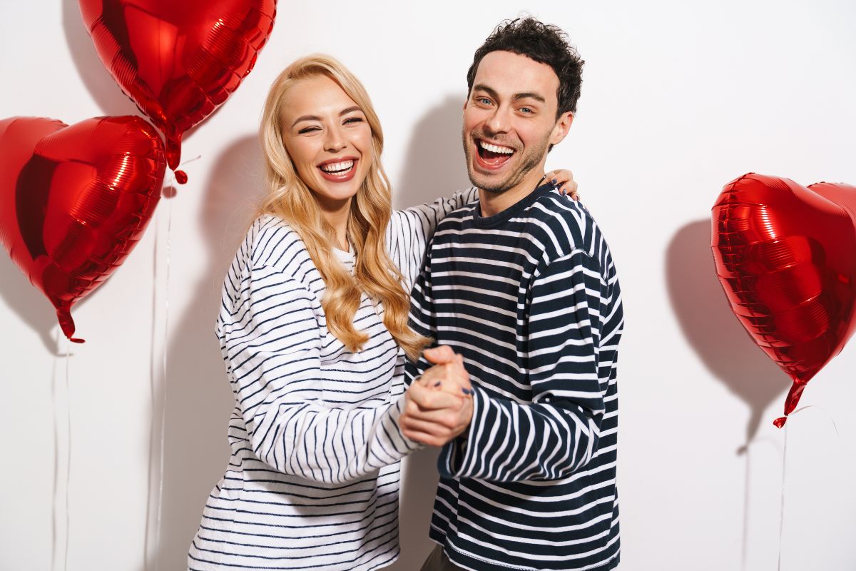 Couple smiling confidently with healthy white teeth on Valentine’s Day.